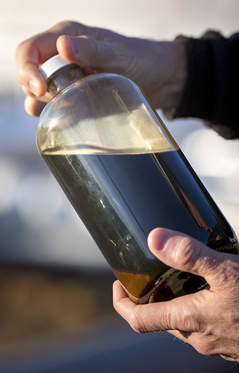 yd7610 employee holding crude oil in container