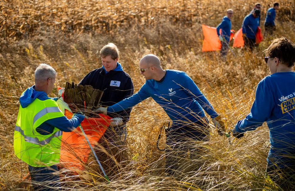 Volunteers put debris in a trash bag