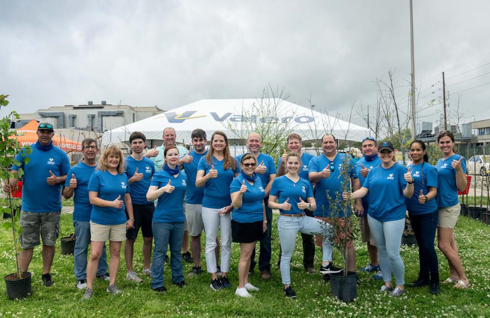 Group of volunteers pose with thumbs up