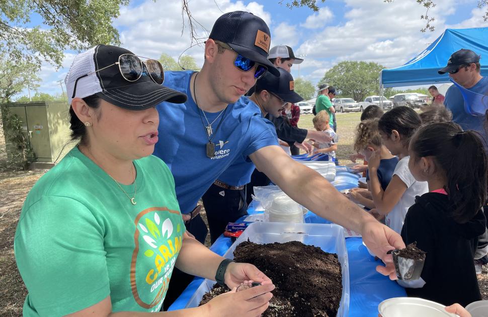 yd7610 volunteers hand out dirt to children for earth day event