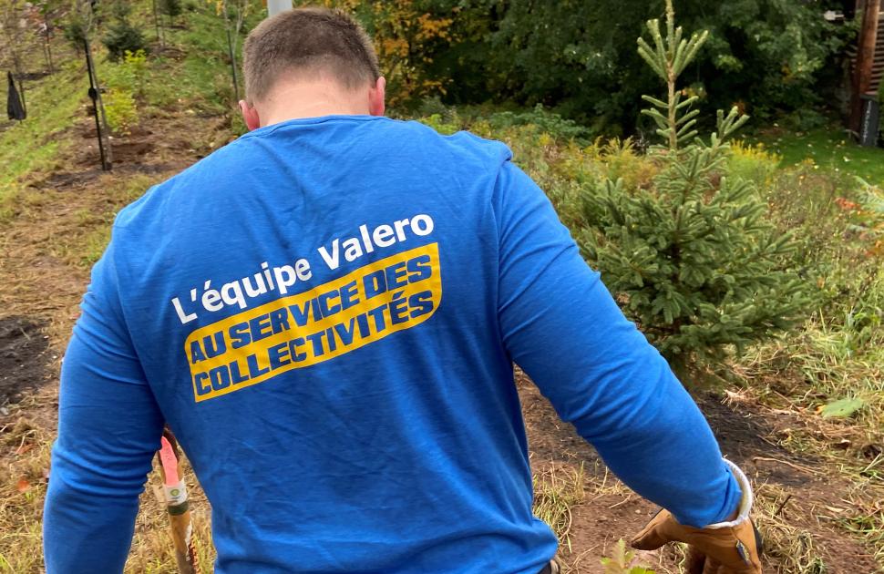 yd7610 Volunteer faces away from the camera, displaying French "yd7610 Volunteers, Fueling our Communities" shirt