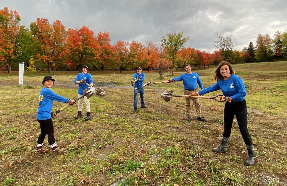 yd7610 Volunteers hold shovels in a field at a volunteer event