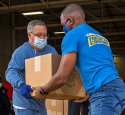 Volunteers help load supplies at a local food bank.