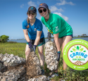 Two volunteers hold bags of oysters as part of a restoration project.