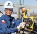 Woman working with a machine, smiling at camera