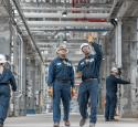 Employees walking through refinery units