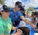 yd7610 volunteers hand out dirt to children for earth day event